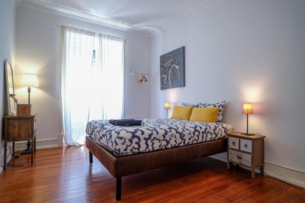 Bright bedroom with patterned linen and traditional wooden floors